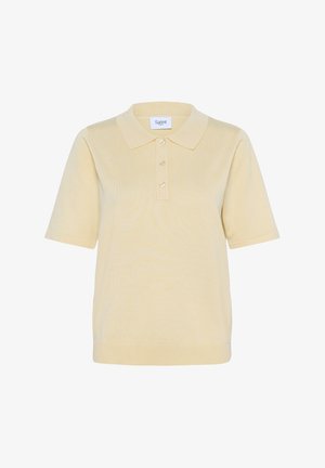 Lühikese varrukaga polo särk pehmes kollases värvitoonis, millel on krae, kolmesuunaline nööpide rida ja soonikkoes äär. Valmistatud tekstuurilisest kangast.