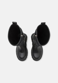 Schwarze wasserdichte Stiefel mit einer glatten Lederaussenfläche, robusten Gummisohlen und einem strukturierten, gepolsterten Schaft. Mit Reissverschlüssen und Zuglaschen.