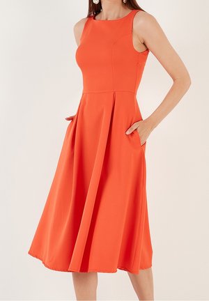 Pomarańczowa sukienka bez rękawów z dopasowanym stanikiem, rozkloszowanym dołem i kieszeniami po bokach. Wykonana z gładkiej tkaniny, o prostych liniach i minimalnych zdobieniach.
