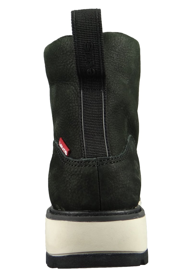 Zwarte leren laars met een gestructureerde afwerking, elastische zijpaneel, rode merketiket en een contrasterende crème en zwarte zool.