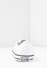 Weiße Leder-Sneaker mit schwarzen Akzenten, niedrig geschnittenem Design und Gummisohle. Merkmale die "Converse All Star"-Markierung auf der Ferse.