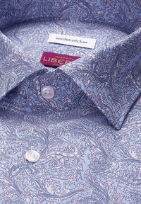 Chemise de ville bleue à motif paisley avec des boutons blancs et des étiquettes de marque cousues à l'intérieur du col.