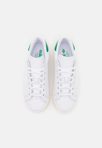 Sneakers bianchi con accenti verdi, dotati di una tomaia in pelle liscia, lati strutturati, sistema di allacciatura a sei fori e suola in gomma.