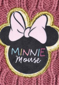 Accessorio in maglia di colore rosa scuro con una toppa rotonda nera di Minnie Mouse, con un fiocco rosa e il testo multicolore che reca la scritta "MINNIE Mouse."