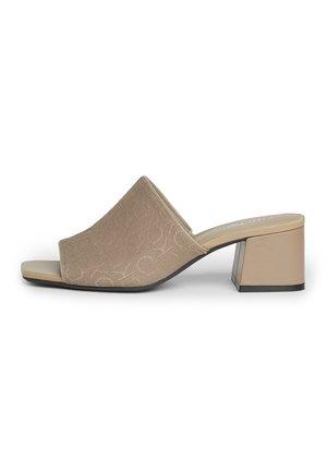Beige åben tå mule med tekstureret stofoverdel, blokhæl og slip-on design vist i sideprofil.