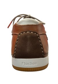 Bruine leren sneaker met een tan suede hak, rubberen zool en contrasterende witte stiksels. Heeft een logo op de achterkant en platte veters.
