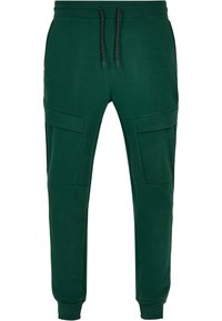 Groene katoenen sweatpants met een trekkoord in de taille, zijvakjes en ribgebreide boorden; gladde textuur en sportieve pasvorm.