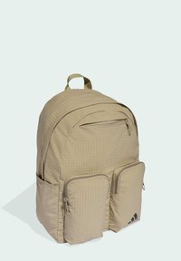 Beige backpack with a textured grid pattern, featuring a top compartment zipper and two front zippered pockets. Accented with a brand logo.