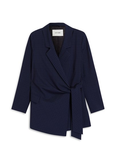 Blazer a quadri blu navy con maniche lunghe, colletto a pico, tasca laterale a pattina e cintura avvolgente con fiocco nella vita destra.