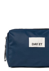 Borsetta cosmetica blu navy con superficie teksturizzata, forma rettangolare, chiusura con zip e un'etichetta in tessuto bianco con la scritta "DAY ET."