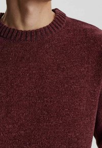 Burgunderfarbener Strickpullover mit geripptem Rundhalsausschnitt, ausgestattet mit einer strukturierten Optik und weichem Stoff, der für Komfort und Wärme sorgt.