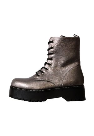 Bottine montante gris métallisé brillant à lacets avec semelle plateforme noire épaisse et surface en cuir texturé sur fond blanc.