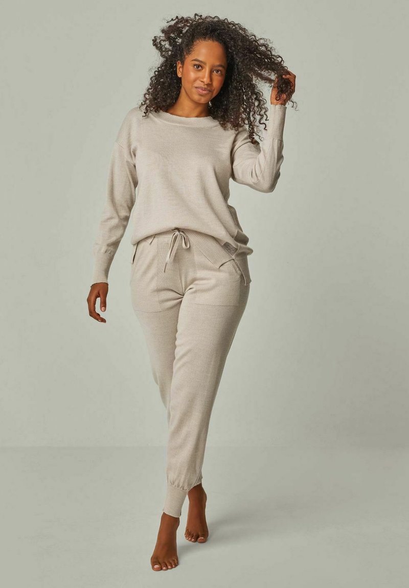 Beige Strick-Loungewear-Set mit einem lässig geschnittenen Pullover mit Rundhalsausschnitt und tapered Hose mit Kordelzugbund und Seitentaschen.
