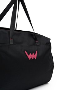 Schwarze Stofftasche mit zwei schwarzen Trägern, die ein pinkes Logo und Akzentnähte entlang der oberen Kante aufweist. Glatte Textur, rechteckige Form.
