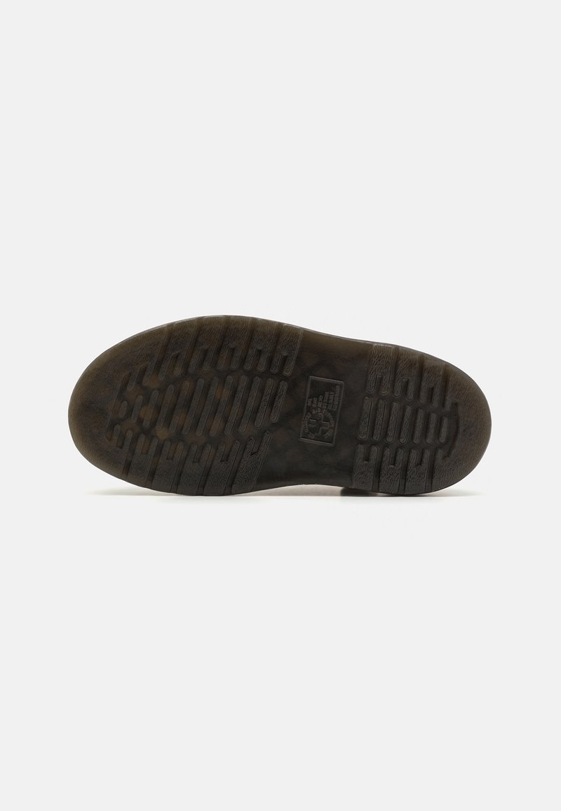 Black rubber shoe sole with textured grip pattern and logo. Round toe with ridged edges for traction. Generally worn and slightly stained.