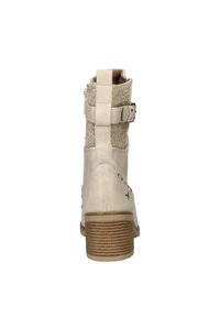 Bottine en cuir beige avec tige en tissu texturé, sangle ajustable, petit accent en métal et talon en bois empilé.