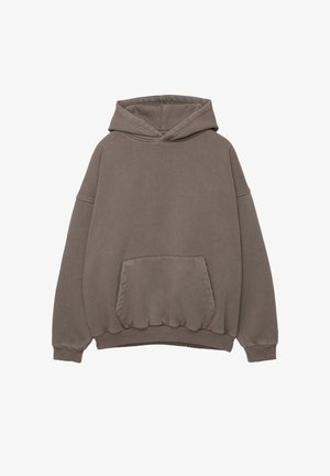 Hoodie in gedämpftem Braun, mit einer Fronttasche, gerippten Bündchen und Saum. Weicher Stoff mit dezentem Logo auf der Brust.