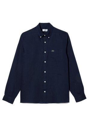 Camisa de botones de manga larga en azul marino, fabricada en tejido ligero, con un pequeño logo verde en el bolsillo del pecho y botones blancos.