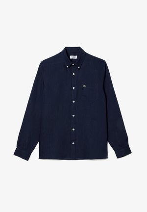 Camicia a maniche lunghe blu navy con bottoni in tessuto leggero, dotata di un piccolo logo verde sulla tasca del petto e bottoni bianchi.