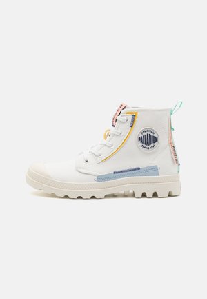 Hvid højtstående lærredssneaker med gummisål, pastelfarvede detaljer, rund Palladium-logo på siden og trækkesløjfe ved hælen.