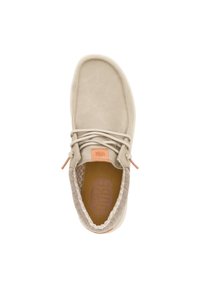 Scarpa beige in suede con punta rotonda, foderatura in tessuto tan testurizzato e etichetta arancione con logo. Presenta un design con lacci e suola a contrasto.