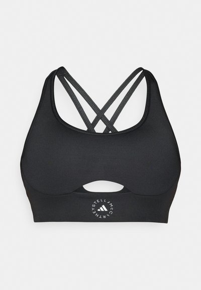 Reggiseno sportivo nero con sottili bretelle incrociate sulla schiena, un piccolo ritaglio sotto il busto e un logo circolare Stella McCartney Adidas sotto.