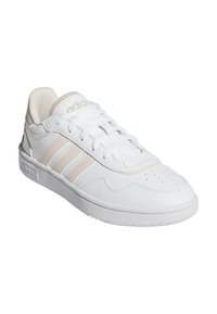 Sneaker sportive bianche con accenti beige, upper in materiale simile alla pelle, punta perforata, tre strisce sui lati e suola in gomma texturizzata.