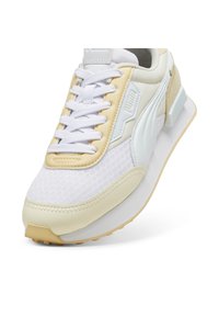 Baskets légères avec un dessus en mesh blanc et des accents jaune pâle, dotées d'une semelle intermédiaire rembourrée et d'une semelle en caoutchouc pour une meilleure adhérence.