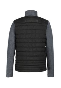 Chaleco acolchado negro con mangas de punto gris. Presenta un cuello alto y un patrón de acolchado horizontal en el cuerpo. Sin hardware visible.