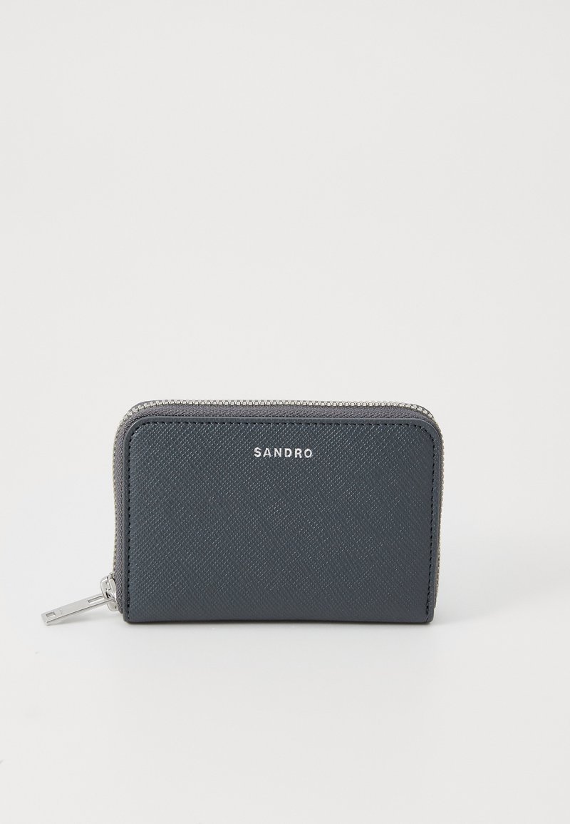 Tumši pelēks rāvējslēdzēja maks ar teksturētu materiālu, sudraba aparatūru un zīmola nosaukumu "SANDRO" iegravētu priekšpusē. Taisnstūra forma.