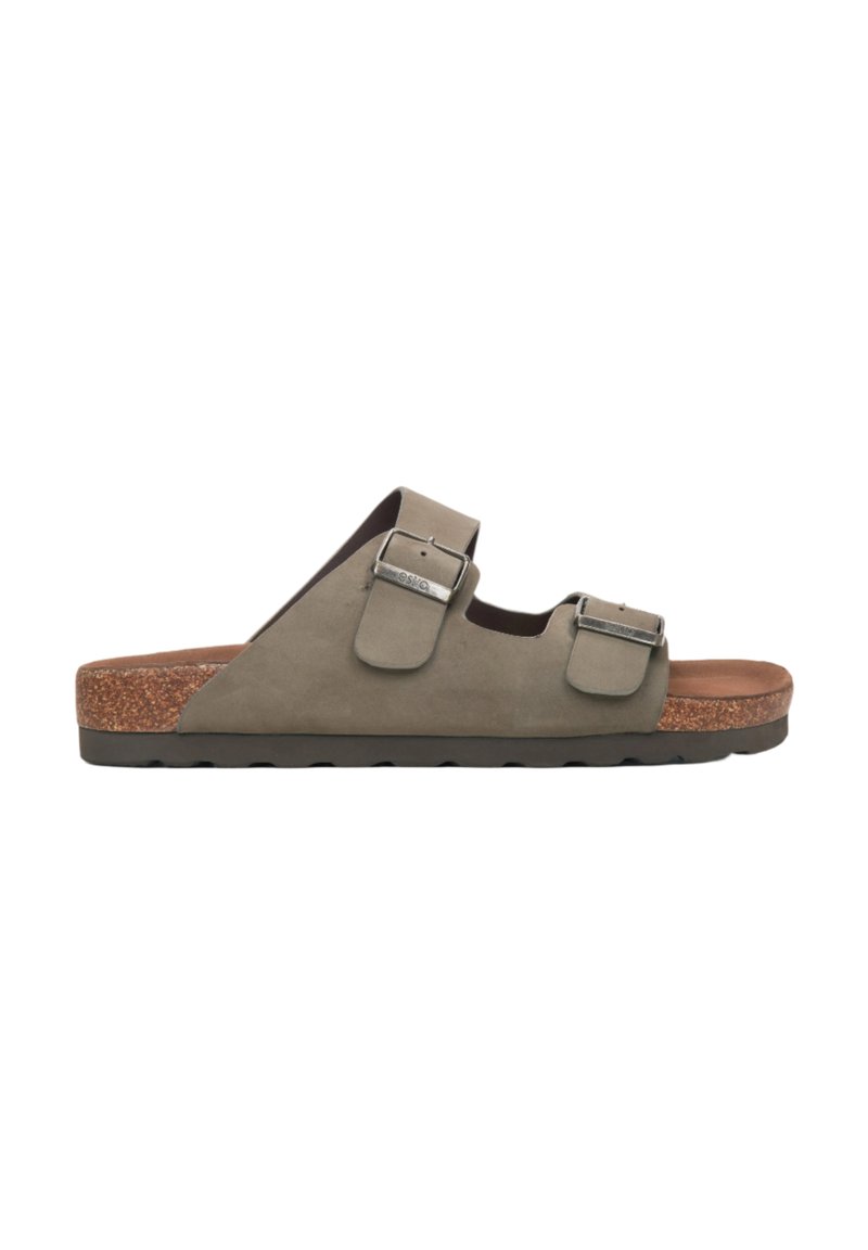 Grijze suede slide sandaal met twee verstelbare metalen gespbanden, kurkachtige middenzool en een bruine, gestructureerde voetbed. Platte rubberen buitenzool.
