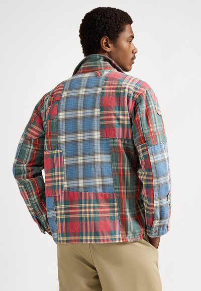 Καρό μπουφάν πατςγουορκ σε κόκκινο, πράσινο και μπλε με διαφορετικές υφές και λεπτομέρειες ραφής. Διαθέτει ψηλό γιακά και μανσέτες με κουμπιά.