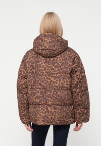 Hnědo-tanová puffer bunda s leopardím vzorem, kapucí a šitými sekcemi, s elastickými manžetami a volným střihem.