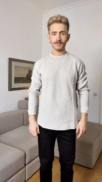 Light gray ribbed long-sleeve shirt with a crew neckline, paired with black slim-fit pants. Textured fabric visible in the shirt's design.