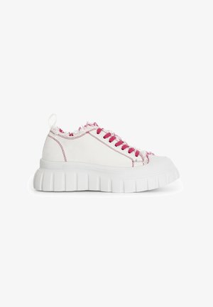 Baskets en toile blanches avec une semelle épaisse blanche, des lacets roses et des bords effilochés le long du col. Embout renforcé et couture contrastante.
