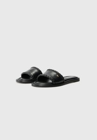Black leather sandals featuring a braided strap design, a flat sole, and minimalistic detailing without visible branding accents.