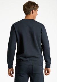 Mörkblå sweatshirt i bomull, med långa ärmar, ribbade muddar och fåll, med en slät textur och en enkel, klassisk design.