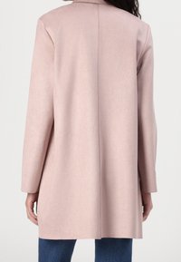 Long, light pink coat with a smooth, suede-like texture. Features a straight cut, long sleeves, and a simple collarless design.