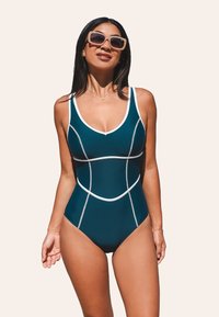 Teal badpak met witte accenten, een V-halslijn en een strakke pasvorm met contrasterende naden. Glad stof met een lichte glans.