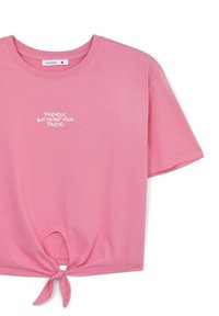 T-shirt corta rosa in tessuto morbido, con scollatura rotonda e maniche corte. Dettaglio annodato all'orlo e testo bianco: "Amichevole, ma non sono tua amica."