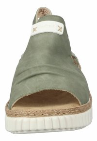 Chaussure ouverte en cuir vert avec bande élastique, accents beiges, semelle intermédiaire en jute de style espadrille et semelle extérieure en caoutchouc blanc durable.