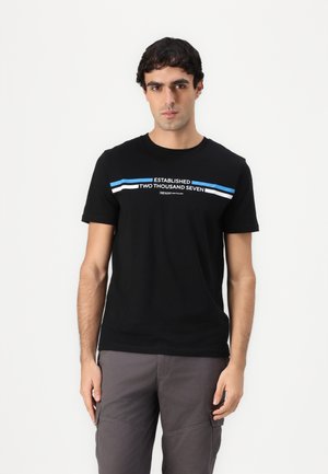 T-shirt en coton noir à manches courtes, avec un graphique en blanc et bleu affichant "ÉTABLI DEUX MILLE SEPT." Coupe classique.