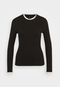 Svart långärmad topp med ribbad textur, som har en vågig vit kant vid halsringning och ärmsöm. Figursydd design.