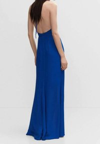 Robe longue sans dos en tissu bleu vif, dotée d'un corsage ajusté, d'une jupe fluide et de fines bretelles. Texture lisse avec un minimum de détails.