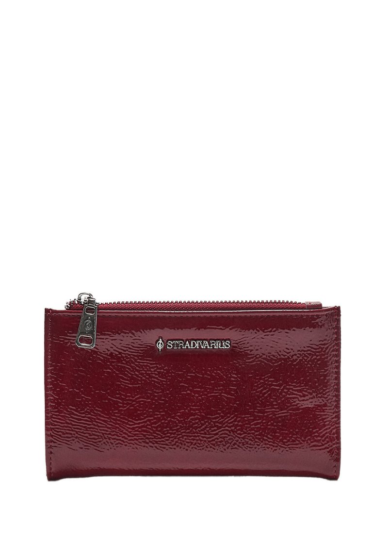 Burgunderfarbene Lackleder-Geldbörse mit glänzender Oberfläche, Reißverschluss und silbernem Logo-Akzent. Rechteckige Form mit strukturiertem Material.