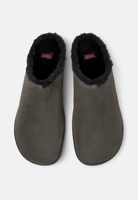 Grå slip-on tøfler med et glat ydermateriale og en blød sort fleeceforing. Rund tå-designet med en flad sål. Rødt logo synligt indeni.