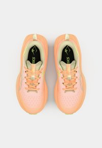 Light pink athletic shoes with a textured mesh upper, beige accents, and green rubber sole. Features flat laces and a cushioned footbed.