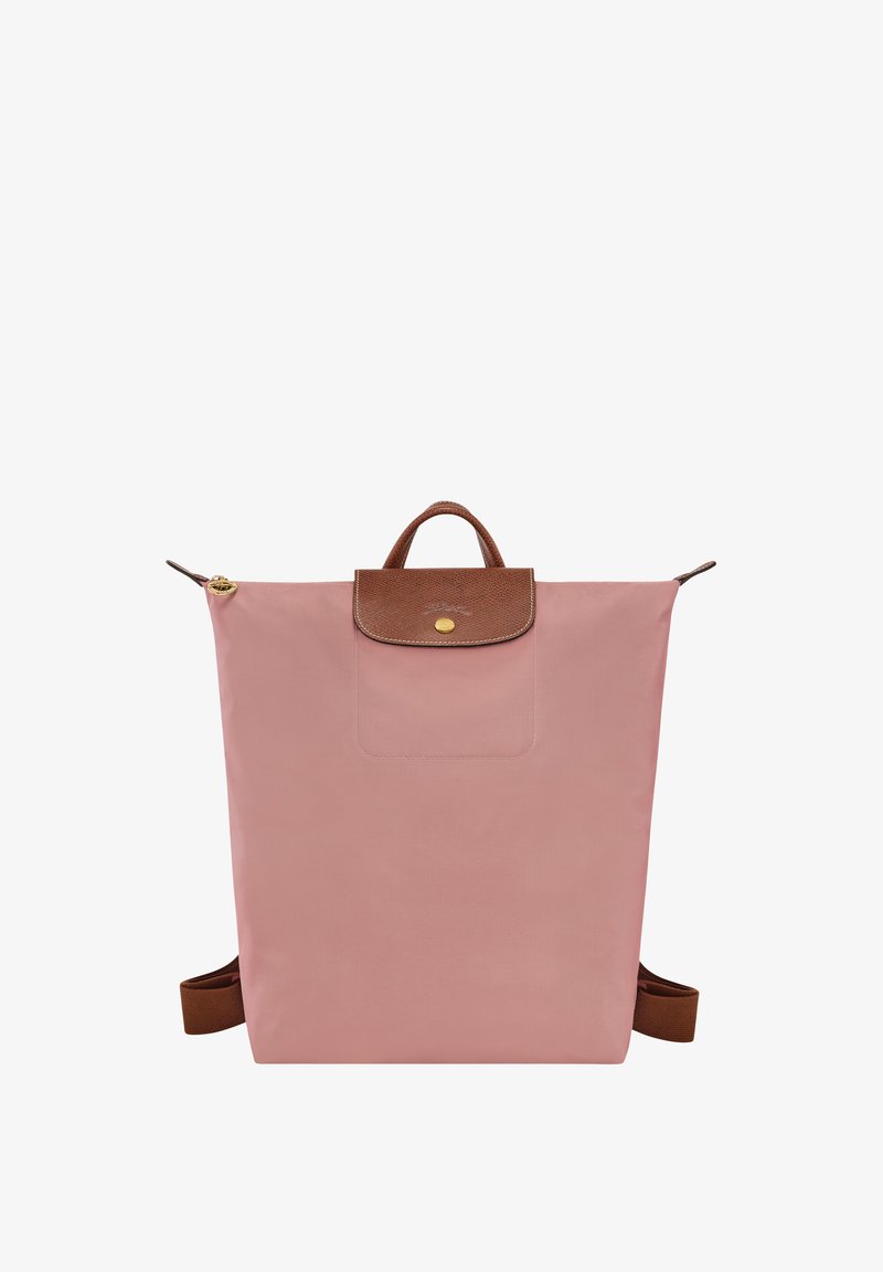 Pink fabric backpack with a brown leather top flap, gold snap closure, and adjustable brown straps. Features a front pocket. Simple rectangular design.