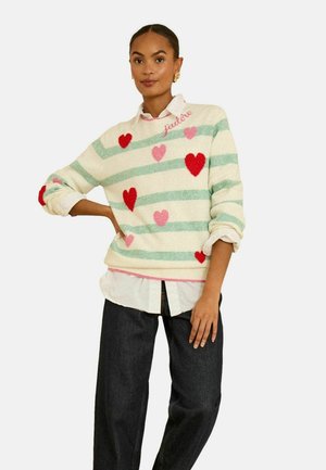 Pulover tricotat crem cu dungi orizontale verzi, decorat cu inimi roșii și roz. Accentele includ un detaliu brodat roz la guler.