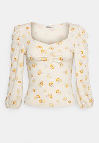 Blusa floral de mangas longas em creme com mangas bufantes. Apresenta um decote quadrado e detalhe franzido na zona do peito, decorada com flores amarelas e laranjas.